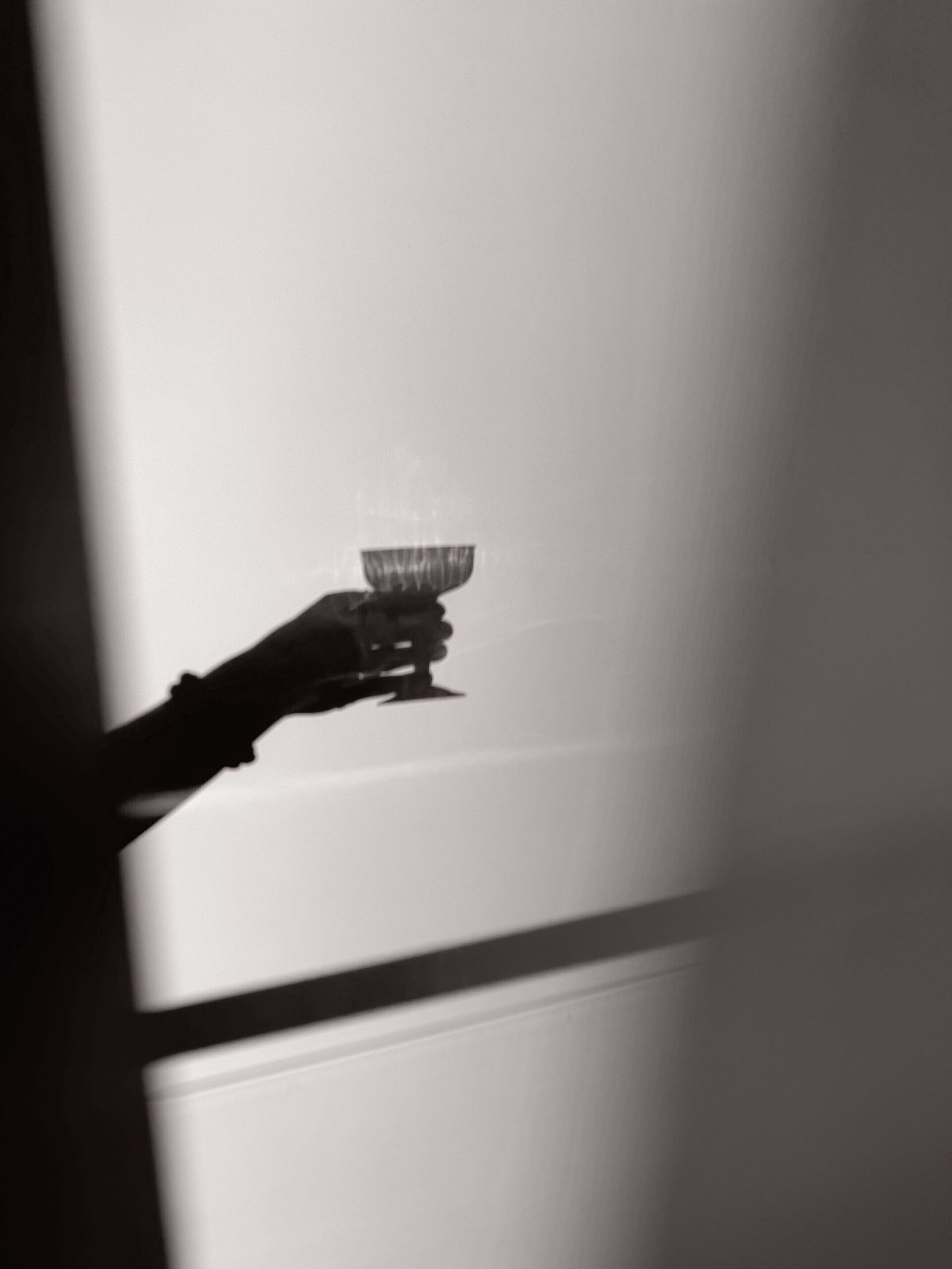 shadow of person holding wine glass